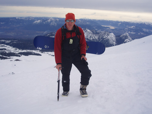 Climbing the volcano above the resort with snowboard on a cloudy day....