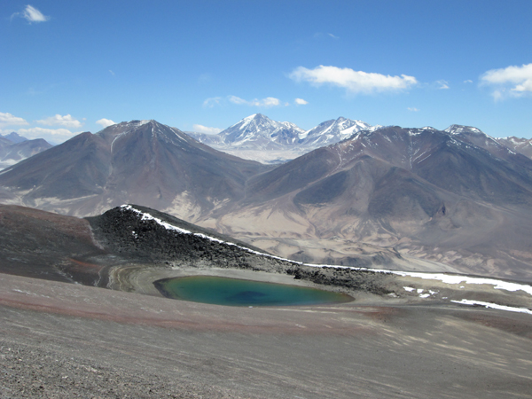 The crater and crater lake on Mulas Muertas. In the background are Vicuas, Tres Cruces Sur and Central (further away) and Barrancas Blancas.