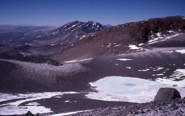 At 6390m on the eastern side of Ojos del Salado there is a permanent c.100m diameter crater lake. 
This appears to be the World's Highest Lake of any size. 